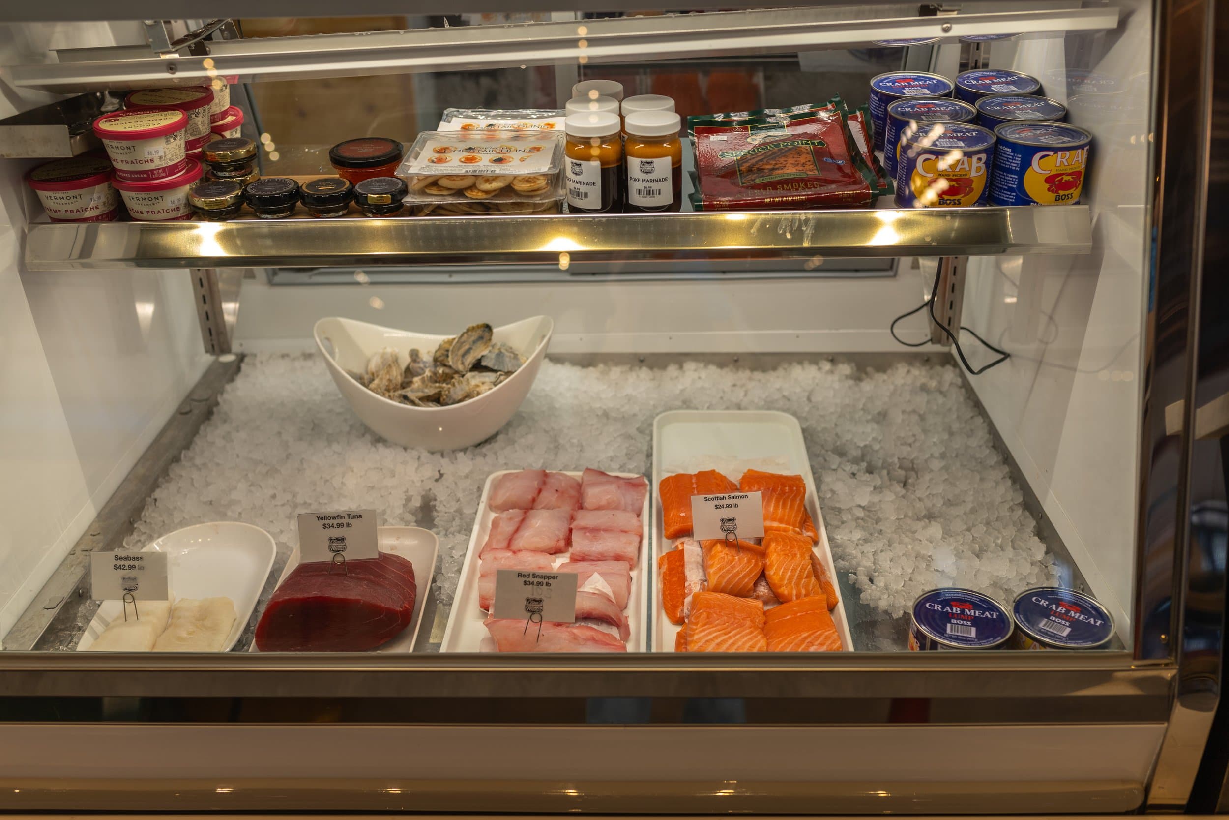 Seafood cold case with fresh fish fillets on ice